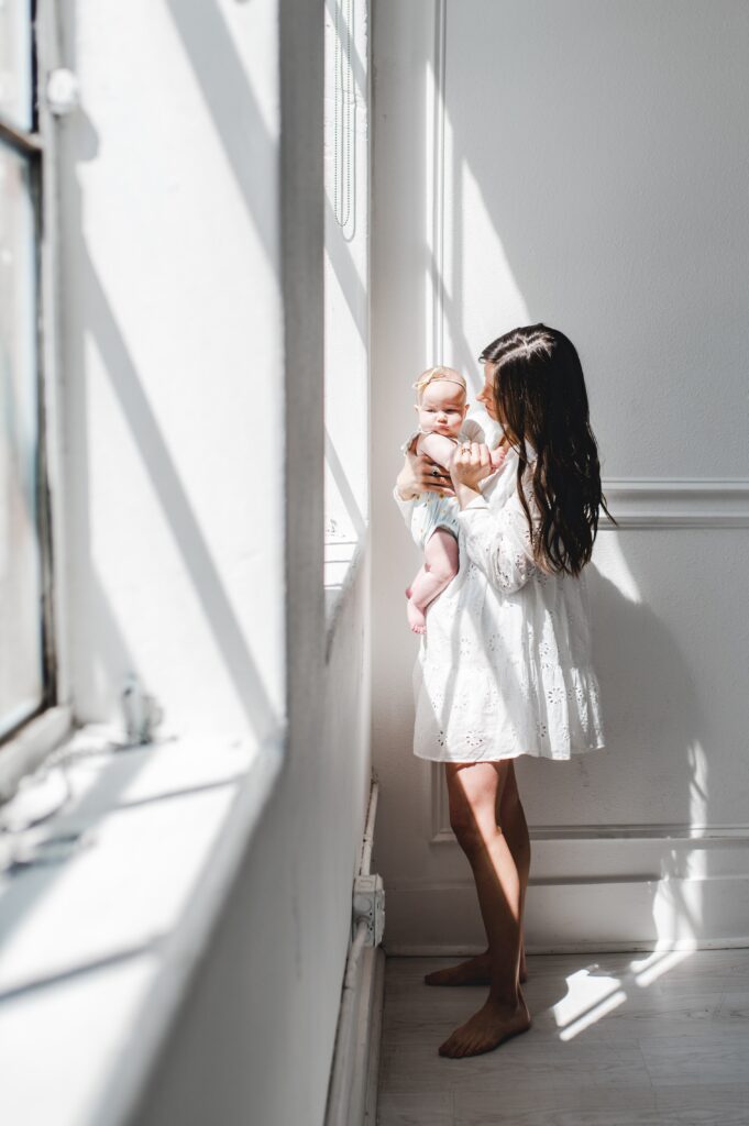inspiration from how sun creates shadows, sunlight streams through a window onto a mother and baby girl