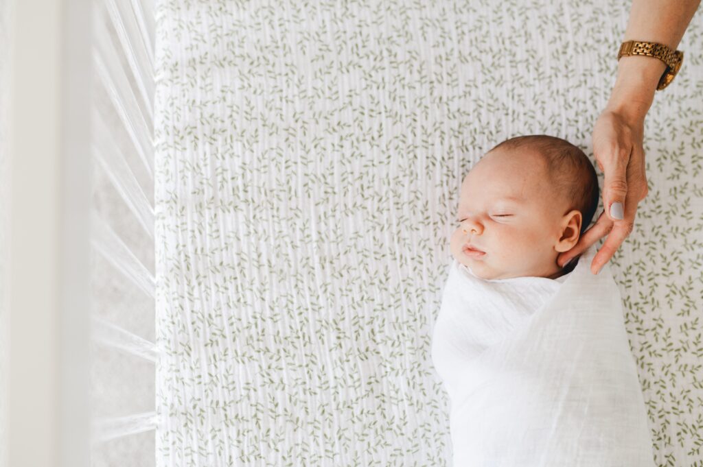 newborn wrapped in a white muslin swaddle
